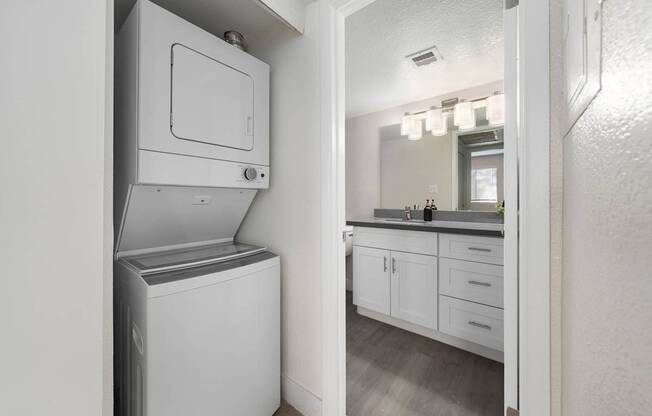 A white dishwasher is in a kitchen next to a white microwave.