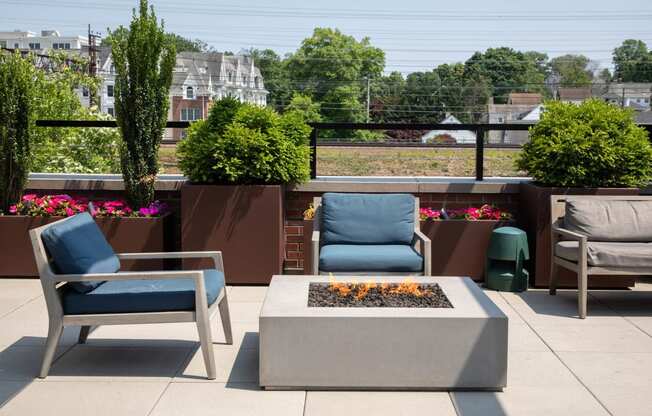 a rooftop patio with two chairs and a fire pit