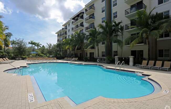 a large swimming pool in front of an apartment building