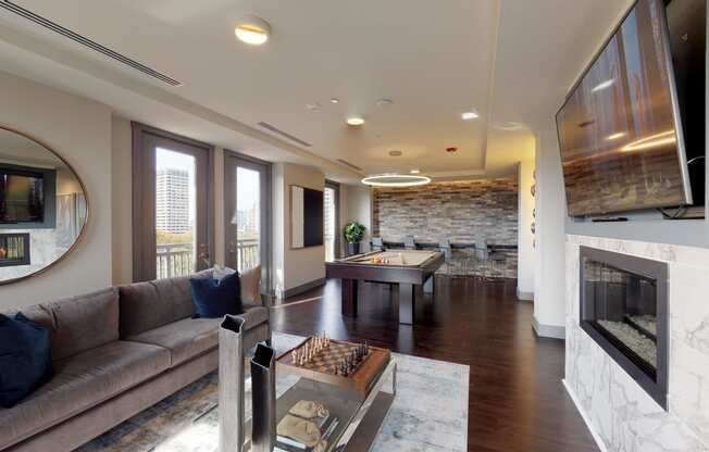 Resident sky lounge facing a pool table and sitting area complete with a television and fireplace.