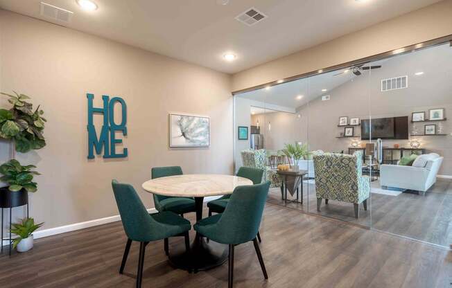 A dining room with a table and chairs and a plant.