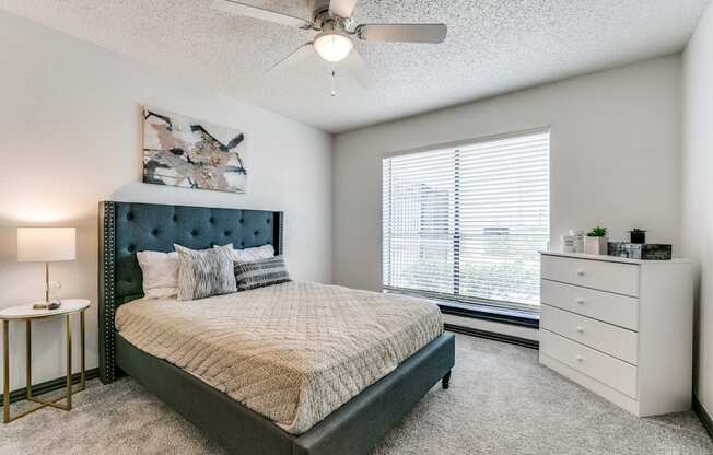 a bedroom with a bed and a ceiling fan