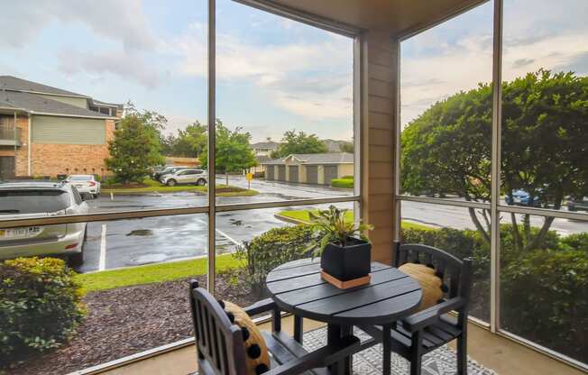 a patio with a table and chairs next to a large window