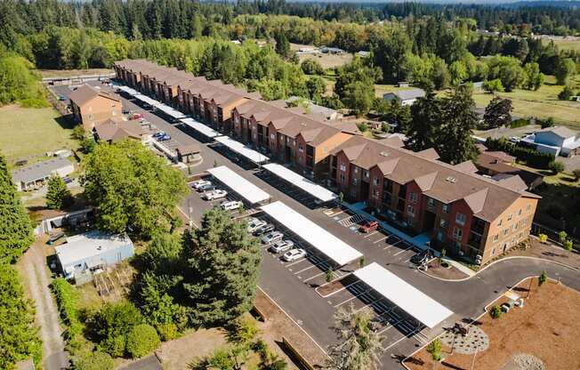 A large building complex with a parking lot in front.