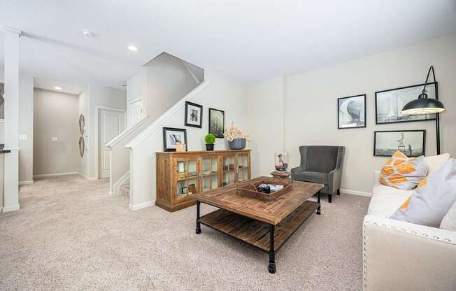A living room with a couch, coffee table, and pictures on the wall.