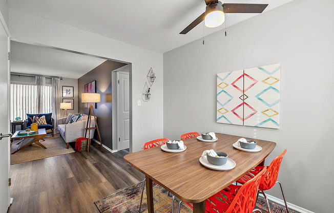 a dining room with a wooden table and chairs and a ceiling fan