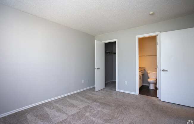 an empty living room with a door open to a bathroom