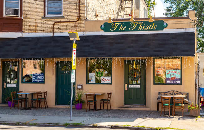 The Thistle restaurant has tables and chairs outside. at Vermella Lyndhurst apartments, New Jersey, 07071