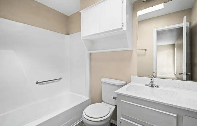 a bathroom with a toilet and a sink and a bath tub at Diamond Ridge Townhomes, Oklahoma City