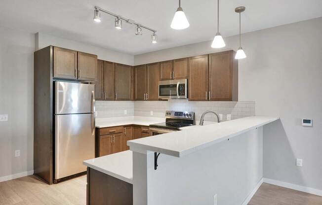 A kitchen with a white counter and wooden cabinets.