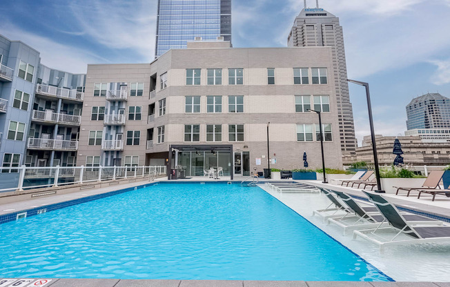 a swimming pool in front of a building in the city