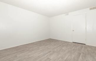 A room with a wooden floor and a white door.