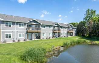 A row of houses with a pond in front.