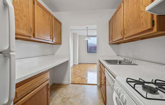 A kitchen with white appliances and wooden cabinets.