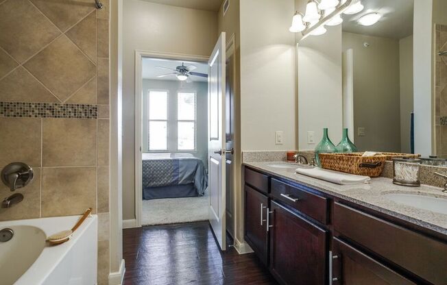 a bathroom with a sink and a shower and a door to a bedroom at Platinum Castle Hills, Lewisville, TX, 75056