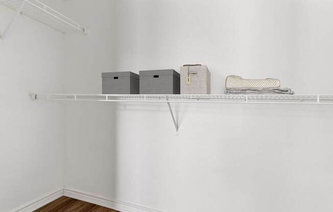 A white shelf with three boxes and a bag on it.