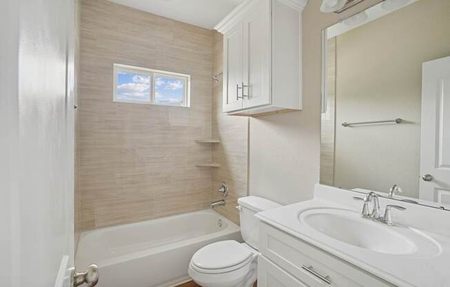 A white bathroom with a tub, toilet, and sink.