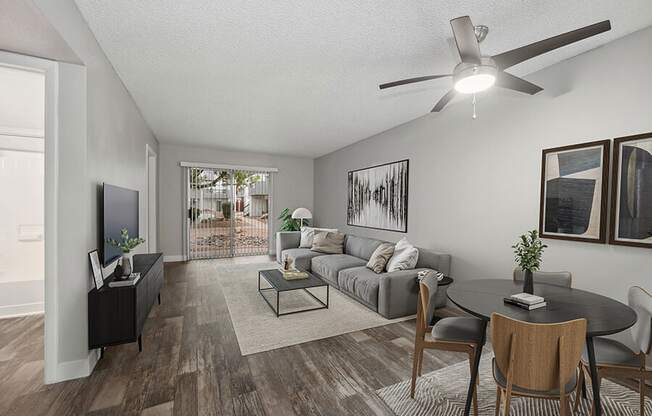 Model Living Room with Wood-Style Flooring and Patio Accessibility at Crystal Creek Apartments located in Phoenix, AZ.