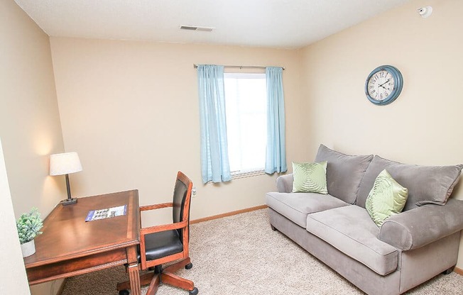 a living room with a couch and a desk