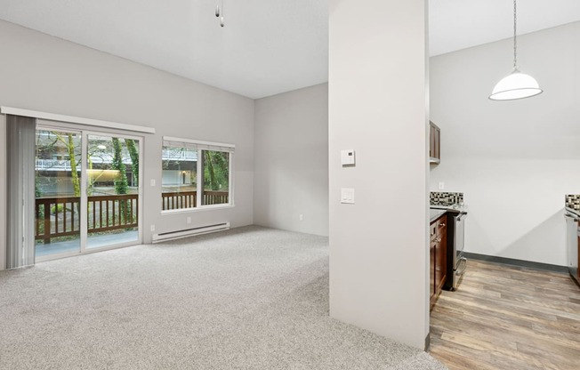 A spacious room with a sliding glass door leading to a balcony.