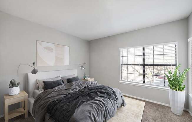 Model Bedroom with Carpet and Window View at Bridges at Oakbend Apartments located in Lewisville, TX.