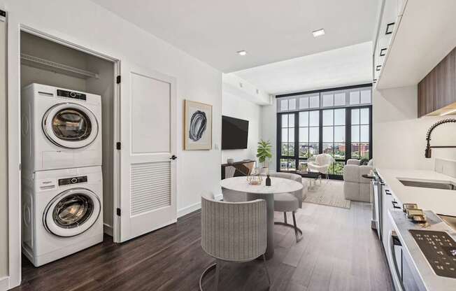 A modern laundry room with a washer and dryer built into the cabinetry.