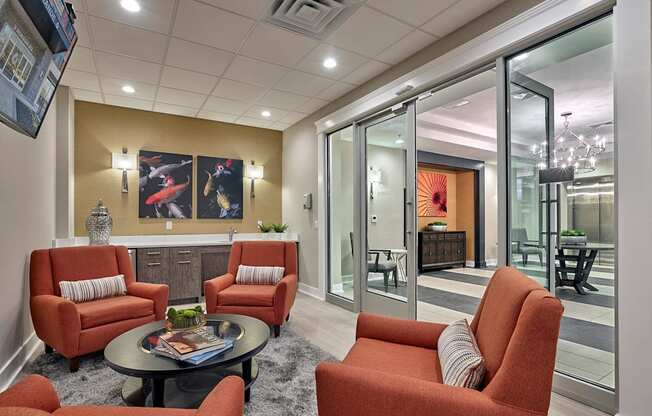 a living room with orange chairs and a table