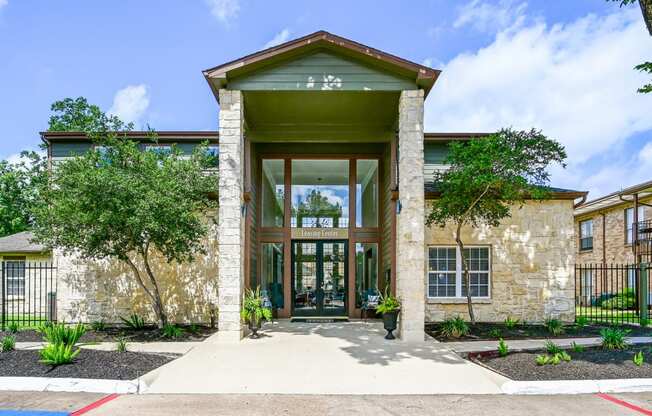 a brick building with a green roof and large glass doors