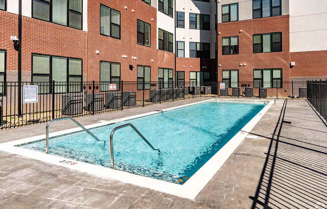 A swimming pool in front of a brick building.