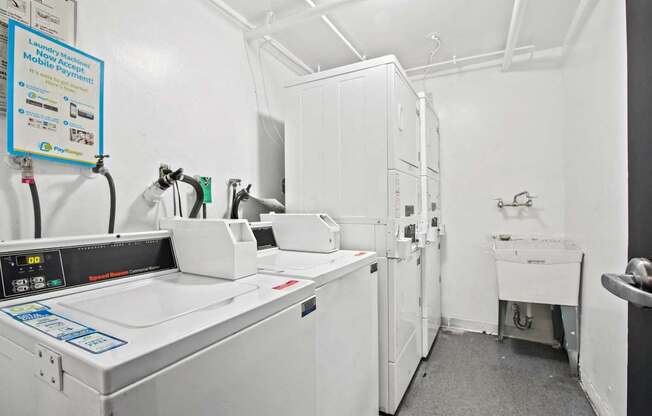 a laundry room with white appliances and white cabinets