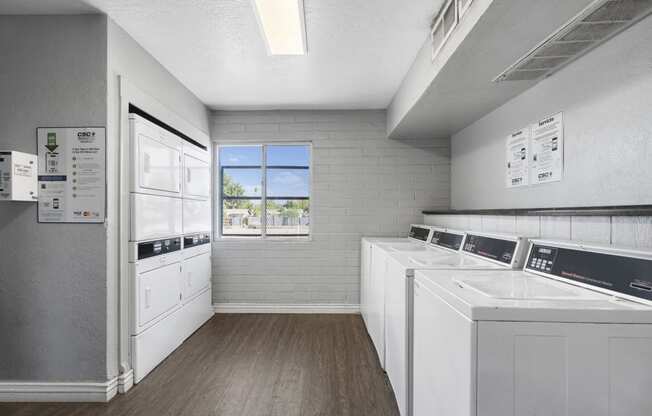 a laundry room with white appliances and a window