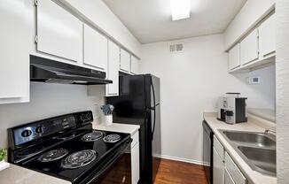 Kitchen with black appliances and white cabinets