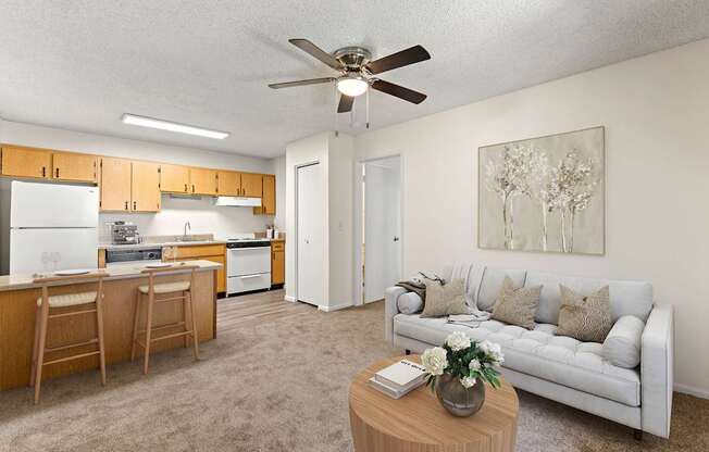 A living room with a couch, a dining table, and a ceiling fan.