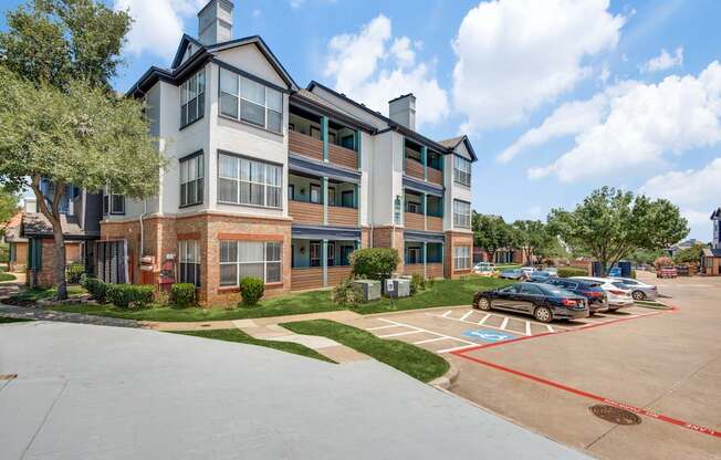 A large apartment complex with a parking lot in front.