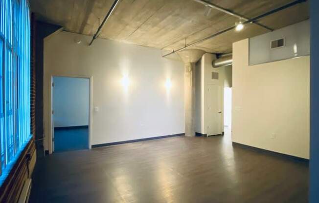 A large empty room with wooden floors and white walls.