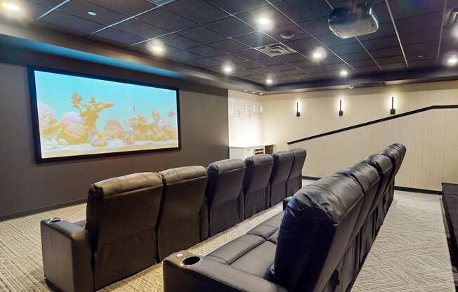 a large screening room with leather chairs and a large screen tv