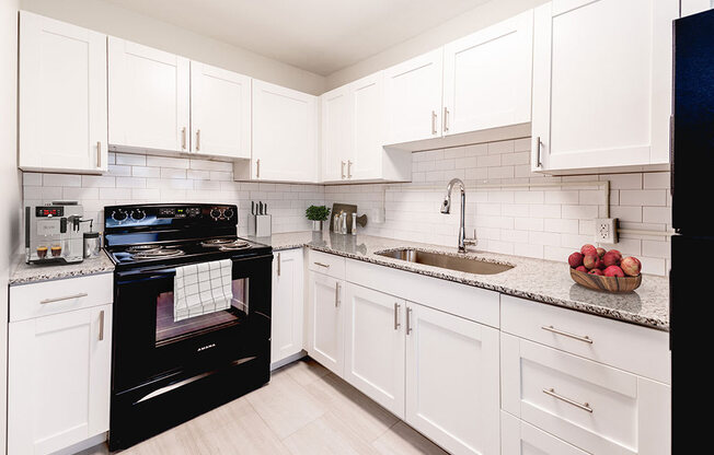 a kitchen with a black stove top oven next to a sink
