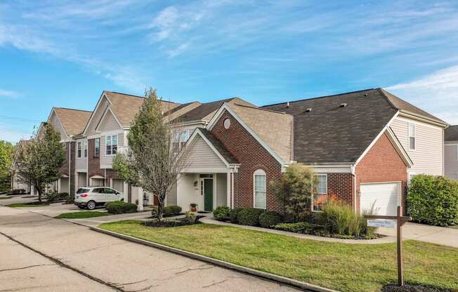 A row of houses with a car parked in front of the first one.