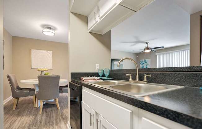 A kitchen with a table and chairs.