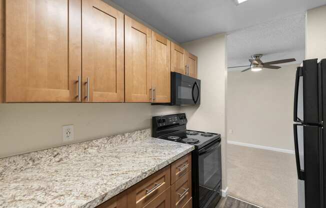 a kitchen with granite-look countertops and black appliances at Park Edmonds Apartment Homes, Edmonds, WA