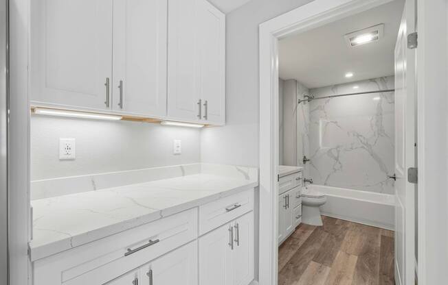 A white bathroom with a marble toilet and sink.