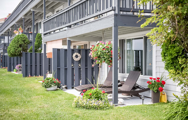 Bass point ground level apartments with patio and beach chairs with lawn overlooking harbor