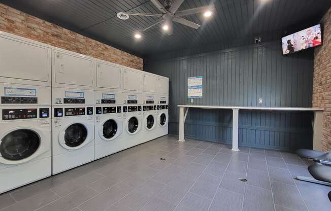 a laundry room with washers and dryers and a table