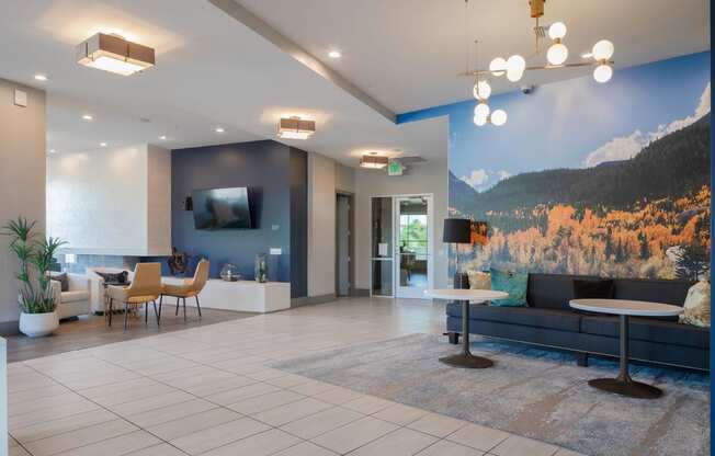 a lobby with a couch table and chairs and a large mural on the wall