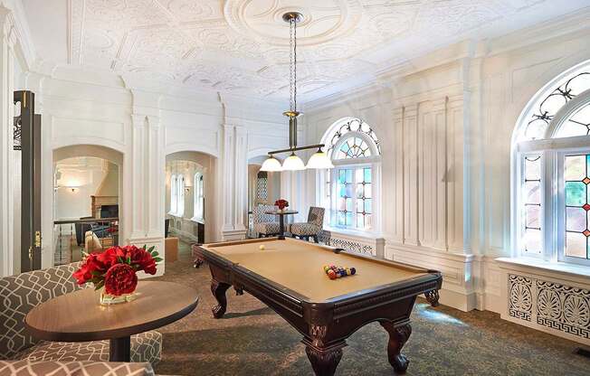 white room with pool table in center at Residences at Forest Park, Saint Louis, MO