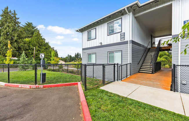 A grey house with a red no parking fire lane.