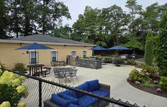 A patio area with tables and chairs and umbrellas.
