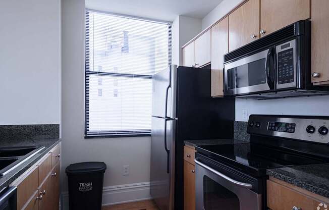 a kitchen with a stove refrigerator and microwave  and a window