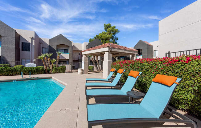 A pool area with blue chairs and a white gazebo.