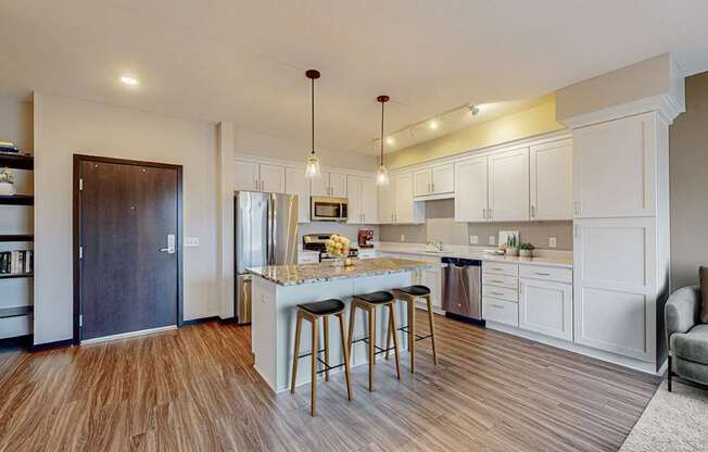 A kitchen with a white countertop and a bar stool.